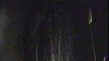 Man gears up to fist a female horse's vagina in the shadows.