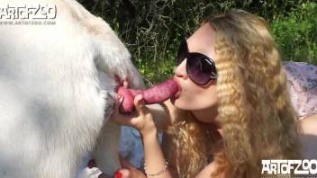 Curly-haired blonde sucking a dog's big dick outdoors