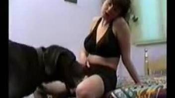 Brunette getting licked by a big black dog