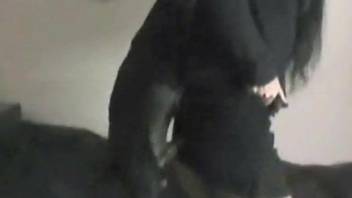 Black dog destroying a hoodie-wearing teen